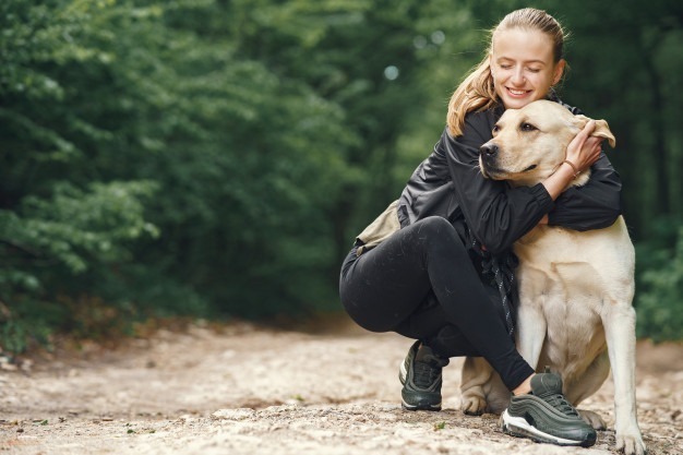 woman cuddling dog outside